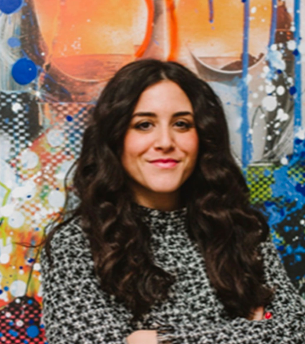 Woman with curly long dark hair with a high neck black and white pattern shirt